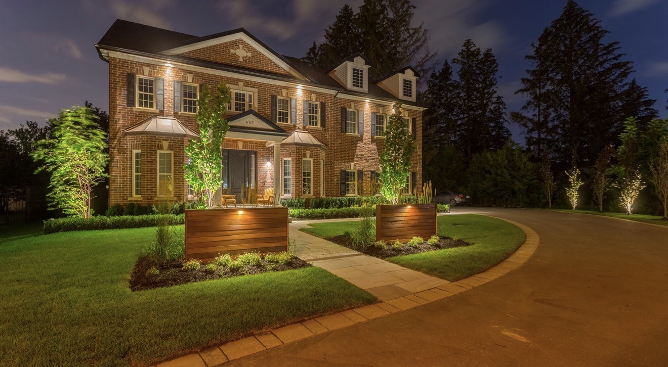 Residential property with an illuminated entrance and curved driveway